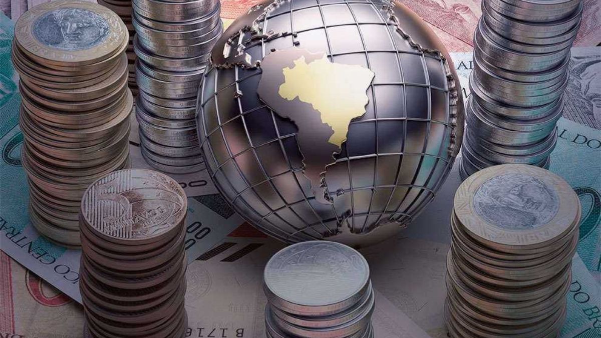 Imagem do globo terrestre, com destaque para porção territorial brasileira que está dourada. Há moedas e notas de dinheiro brasileiro cercando a terra em alusão à política do mundo política monetária fed banco central bc reunião mercados