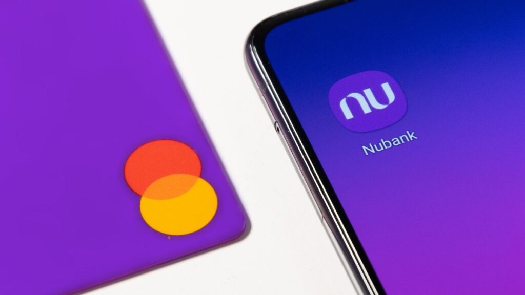 tela de celular estampa símbolo do aplicativo do Nubank ao lado de cartão do roxinho Nu NUBR33