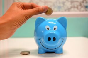 Imagem representando a poupança, mostrando um cofre de porquinho com moedas
