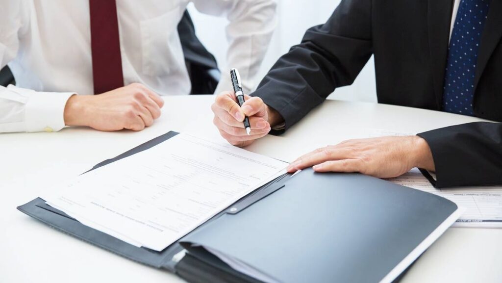 Imagem representando oCDS, mostrando dois profissionais fechando um contrato financeiro.