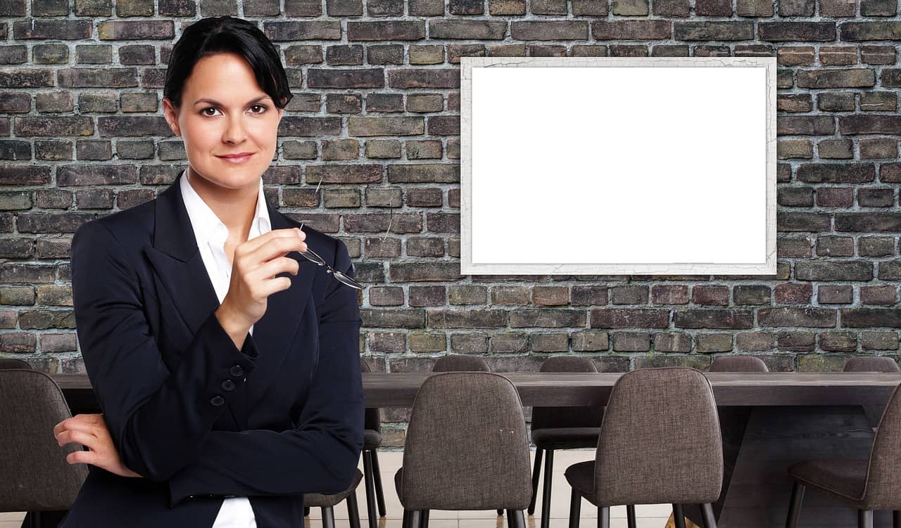 Imagem representando o CGA, mostrando uma mulher de negócios em frente a uma sala de aula.