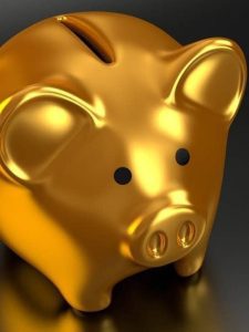 Imagem representando o investimento em ouro, mostrando um cofre de ouro no formato de porquinho.