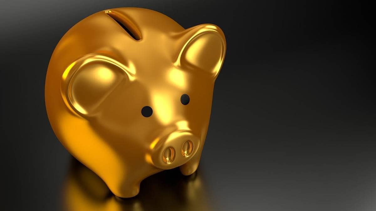 Imagem representando o investimento em ouro, mostrando um cofre de ouro no formato de porquinho.