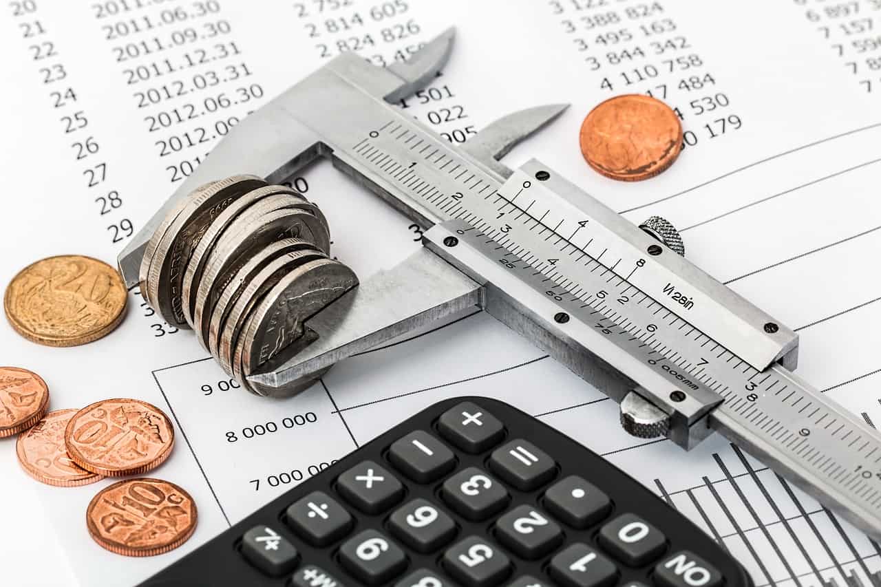 Imagem com calculadoras e moedas representando como declarar aluguéis no imposto de renda.