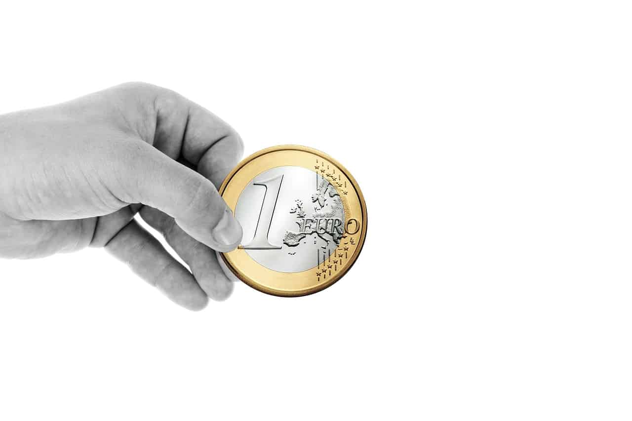 Imagem com uma mão segurando uma moeda representando como declarar doações no imposto de renda (IR).