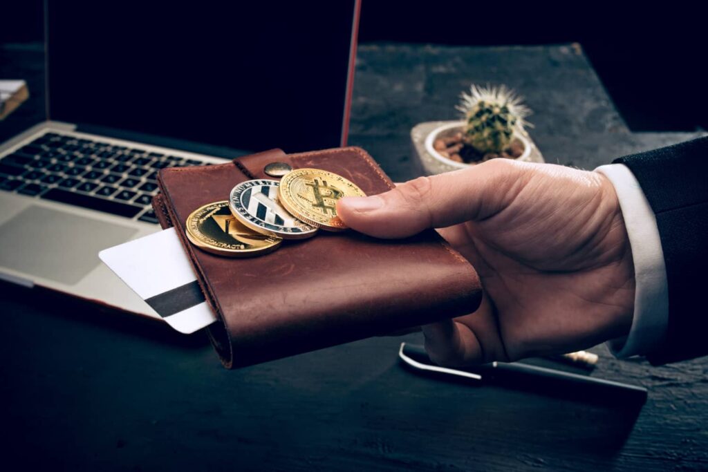 Imagem representando a mineração de criptomoedas, com uma pessoa segurando uma carteira com criptomoedas. bitcoin criptomoedas