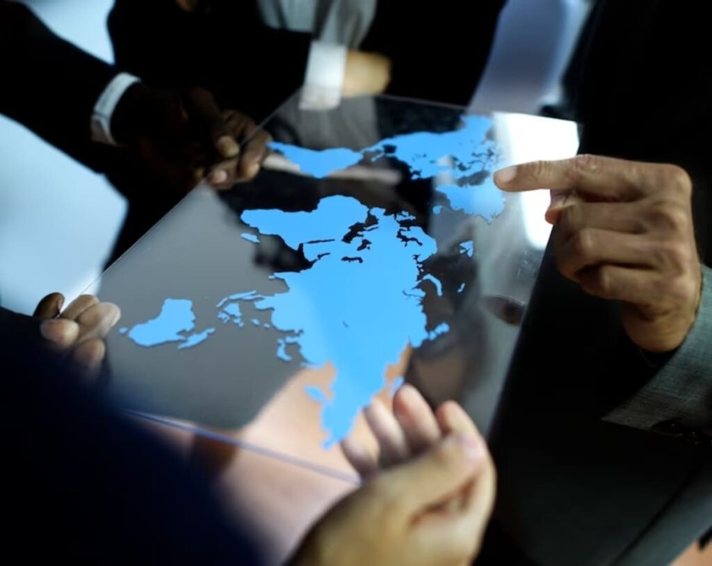 Imagem representando investir no exterior, contendo investidores analisando um mapa digital.