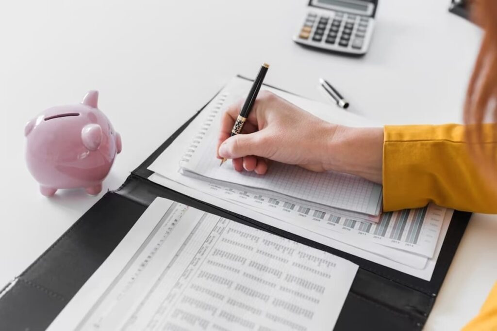 Imagem de uma pessoa fazendo contas e uma calculadora para representar os títulos de crédito.